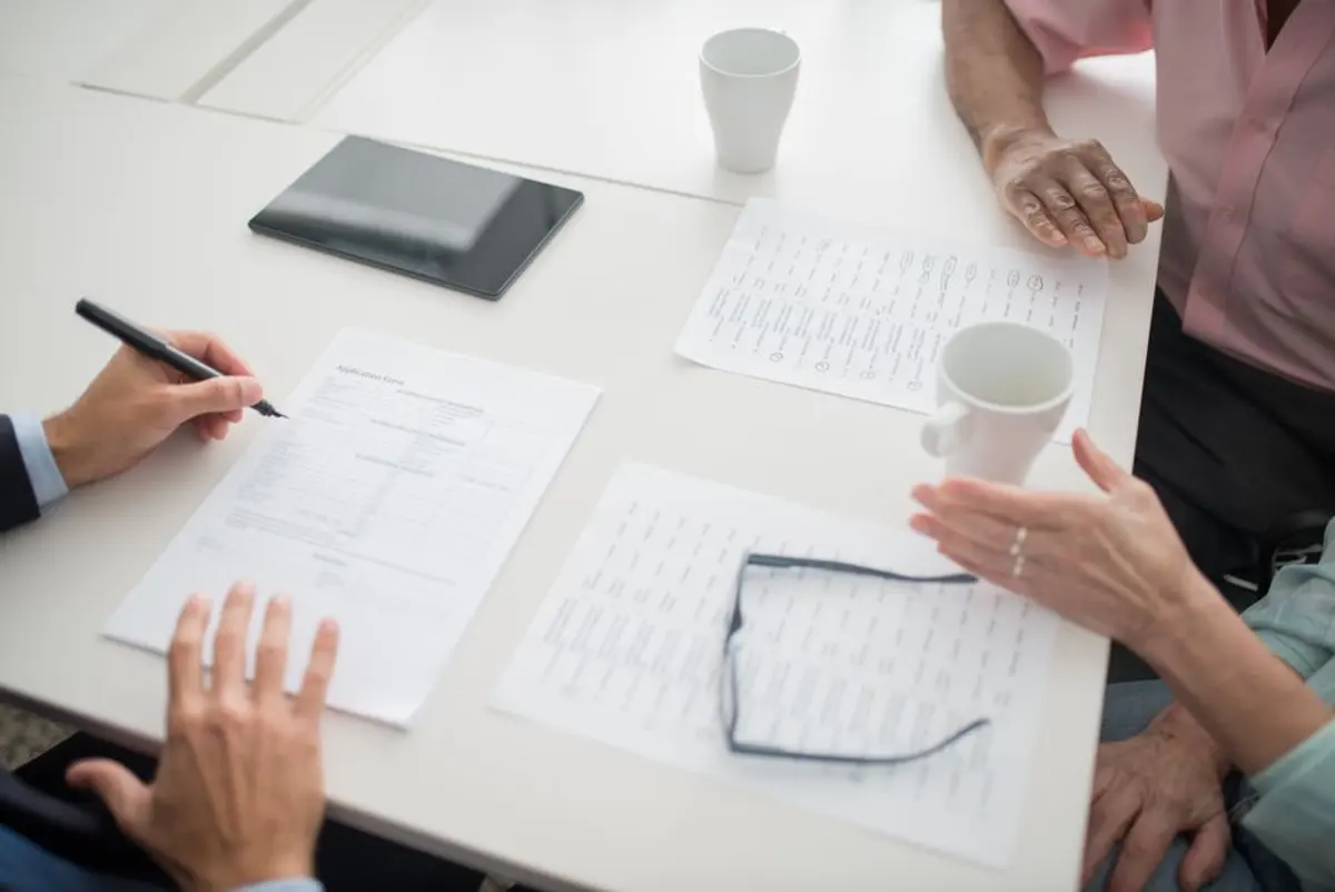 Un dirigeant compare des niveaux de prévoyance, documents et calculatrice sur son bureau